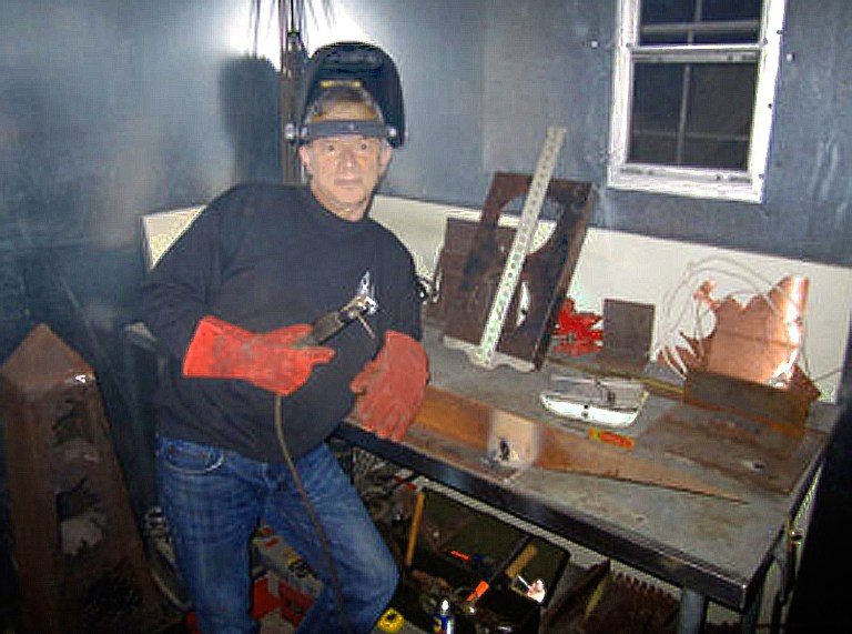 A man in black shirt holding a drill.